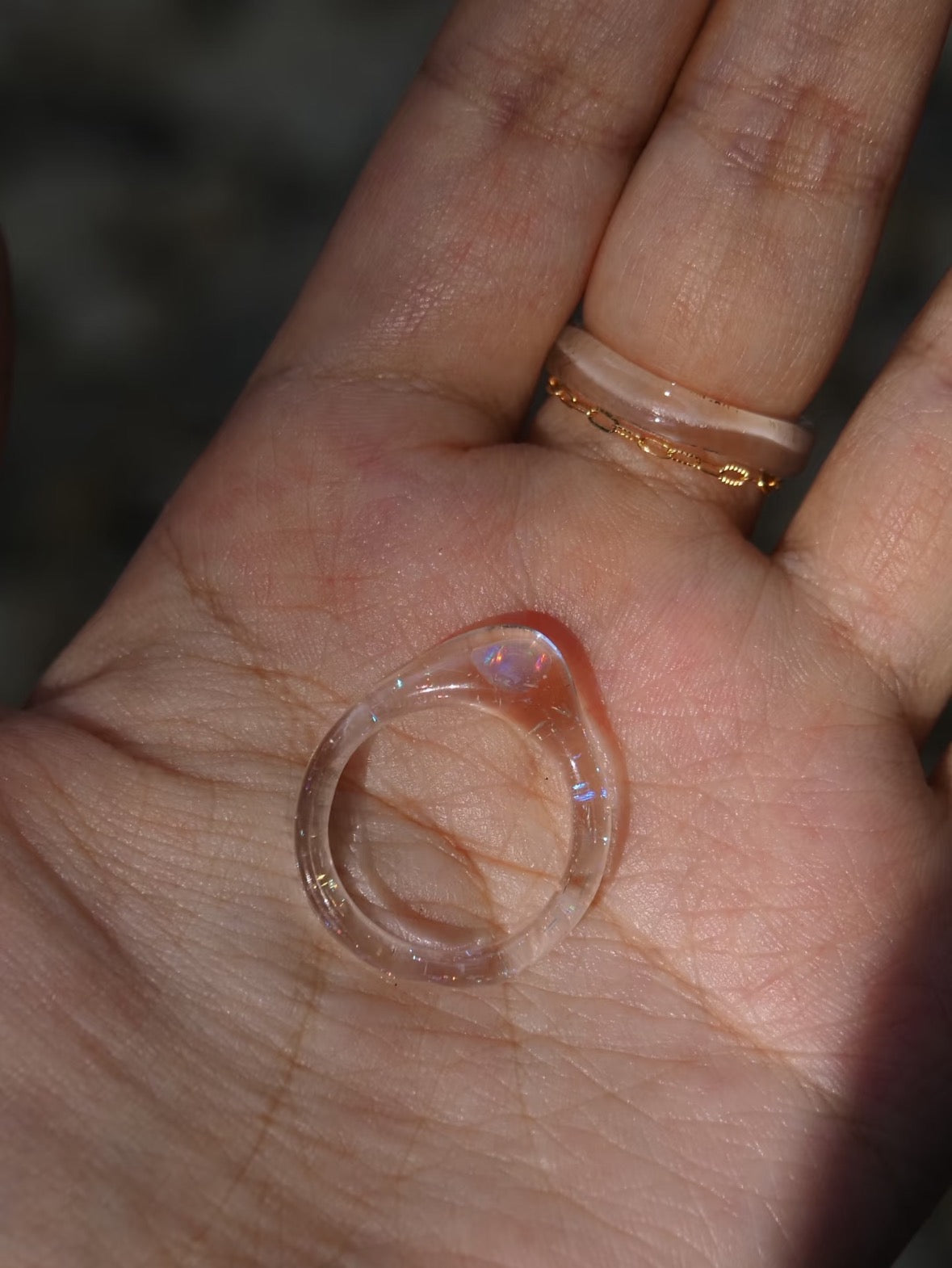 Opal glass ring resting on an open palm, showing the band and profile.
